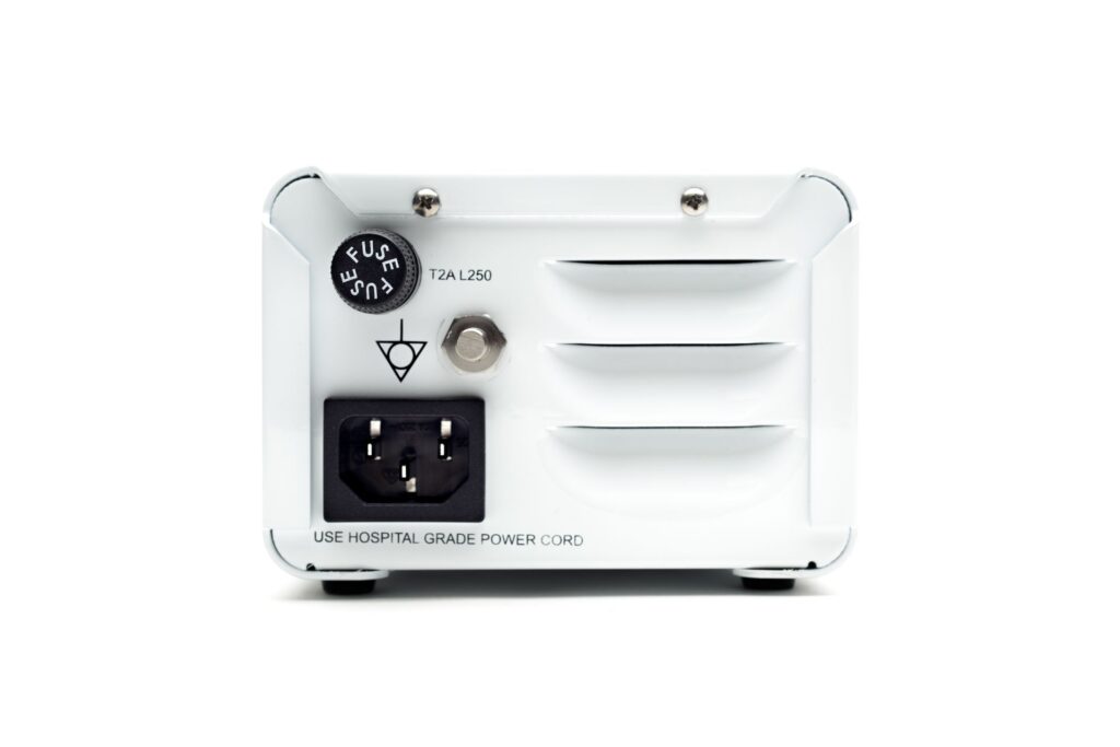 The back of a white electronic device with a black electrical outlet.