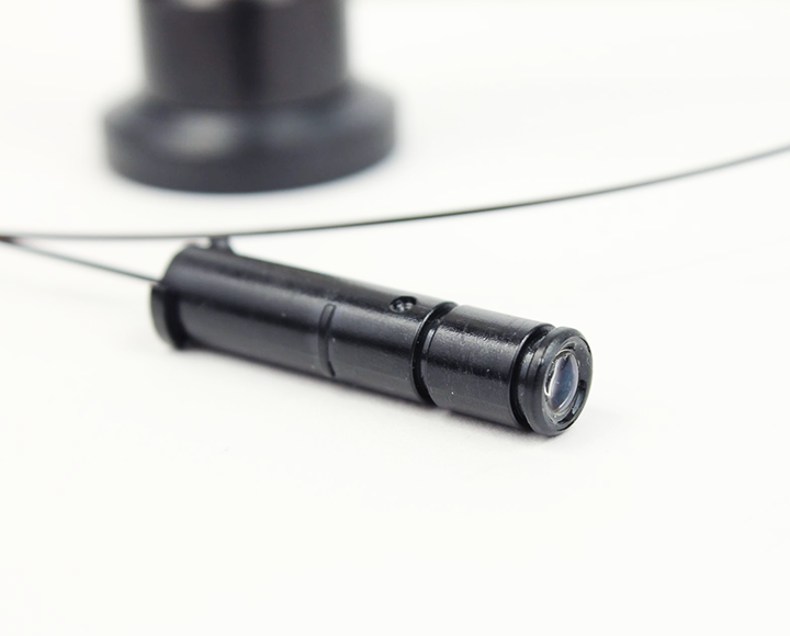 A small black object is sitting on a white surface